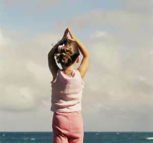 Enfant sur la plage qui fait de la sophrologie